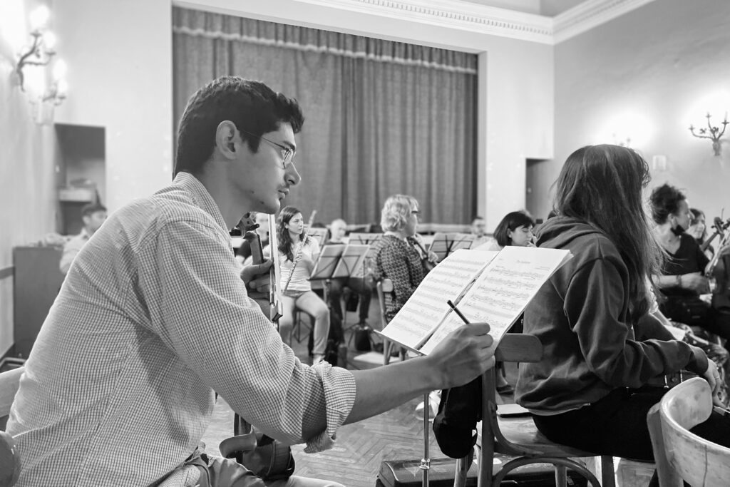 violinist taking notes on his musc sheets during orchestra rehersals